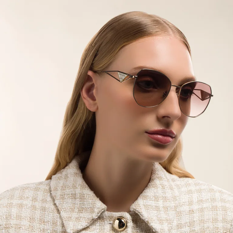 Shop PRADA Irregular Sunglasses in Gold online.